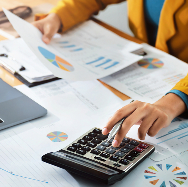 Person using calculator whilst looking at energy bills